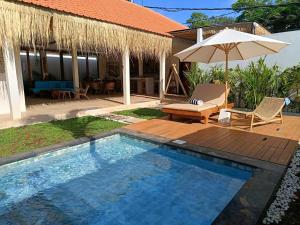 - Piscina con mesa y sombrilla en Villa 10 Rose Bali 3BR Luxury en Ungasan