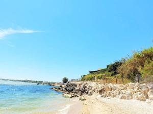 una spiaggia con rocce e l'oceano in una giornata limpida di Verde Mare Isola a Carrozziere