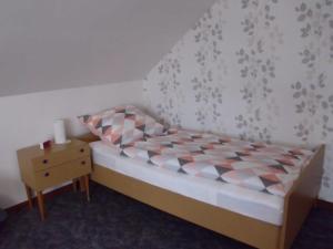 Habitación pequeña con cama y mesita de noche en Ferienhaus, en Weiler