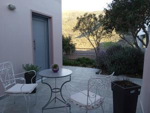 a patio with a table and chairs and a door at Andros Lighthouse Apartments in Mesariá