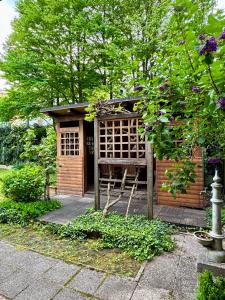 a small wooden building with a gate in a garden at Central Villa with Garden in Ljubljana