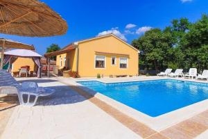 - une piscine avec des chaises et une maison dans l'établissement Ferienhaus mit Privatpool für 10 Personen ca 130 qm in Paradiž bei Vodnjan, Istrien Südküste von Istrien, à Juršići