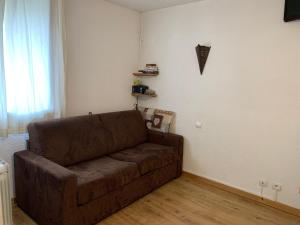 - un salon doté d'un canapé brun dans l'établissement Studio Les Menuires, 1 pièce, 2 personnes - FR-1-452-144, aux Menuires