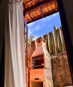 a view through a window of a pizza oven at Pousada Chalés Sinbad in Ilhabela