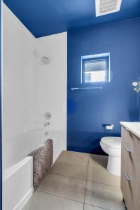 a blue and white bathroom with a tub and a toilet at Hyve in Nashville