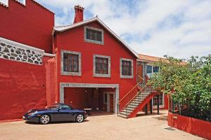 a blue car parked in front of a red building at Ferienhaus für 10 Personen in Arucas, Gran Canaria Nordküste Gran Canaria in Arucas