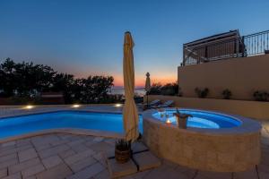 einen Pool mit Sonnenschirm und eine Terrasse mit Pool in der Unterkunft Ferienhaus für 8 Personen und 2 Kinder in Podstrana, Dalmatien Mitteldalmatien in Podstrana