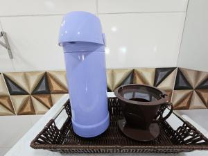 una tazza blu seduta su uno stendino con una tazza di caffè di Apt Novo prox Paraguai e Itaipu a Foz do Iguaçu