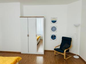 een woonkamer met een stoel en een spiegel bij Studio Apartment Bluebell in Bratislava
