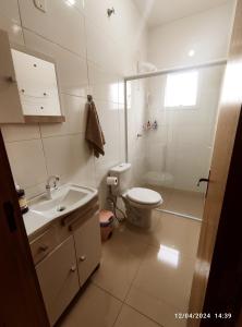 a white bathroom with a toilet and a sink at Sobrado novo vista para o Cristo in Encantado