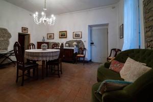 uma sala de estar com uma mesa e um sofá verde em B&B Cortebonomini apartment em Neviano degli Arduini