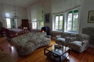 uma sala de estar com um sofá, cadeiras e uma mesa em B&B Cortebonomini apartment em Neviano degli Arduini