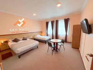 um quarto com 2 camas, uma televisão e uma mesa em Sky Osorno em Osorno