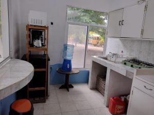 a kitchen with a counter and a sink and a window at Luz del Mar Bungalos in Sipacate