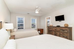 a bedroom with two beds and a flat screen tv at 311B - True Beachfront w/ Private Walkway and Pool in Myrtle Beach
