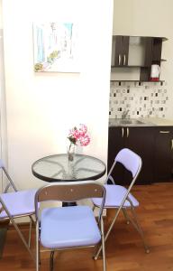 una mesa con dos sillas y una mesa con flores. en Апартамент Поморие плажен комплекс, en Pomorie