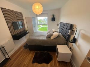 a bedroom with a bed and a television in it at Manchester's Luxurious 3-Bed Haven with Balcony & Free Parking - Canal Views & Proximity to Manchester United in Manchester