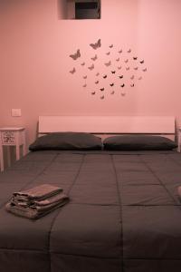 a bedroom with a bed with butterflies on the wall at La Ponzianina in Spoleto
