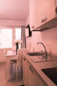 a kitchen with a sink and a table with a vase of flowers at La Ponzianina in Spoleto +13 photos