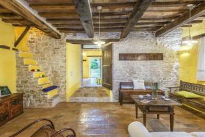 een woonkamer met een tafel en een stenen muur bij Ferienhaus für 12 Personen in Cagli, Marken Provinz Pesaro-Urbino in Cagli