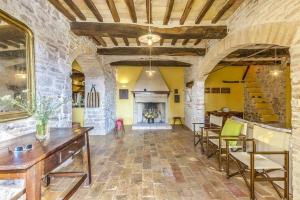 Habitación grande con chimenea, mesas y sillas. en Ferienhaus für 12 Personen in Cagli, Marken Provinz Pesaro-Urbino, en Cagli