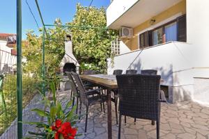 eine Terrasse mit einem Tisch, Stühlen und einem Kamin in der Unterkunft Ferienhaus für 12 Personen in Preantura, Istrien Istrische Riviera in Premantura