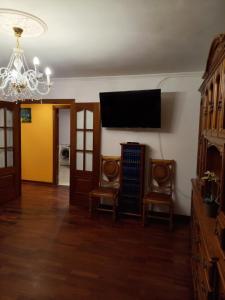 een woonkamer met 2 stoelen en een flatscreen-tv bij Vacaciones in Cedeira