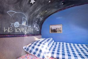 a bedroom with a bed and a chalkboard wall at Teasel Shepherd's Hut in Berwick-Upon-Tweed