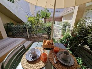 a table with two plates and a basket of bread at BELAZUR Entre plage et port in Bandol