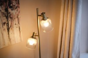 two lights on a wall next to a curtain at Lambert Cottage - In the Heart of Stamford in Stamford
