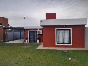 un bâtiment en briques rouges avec une fenêtre et une cour d'herbe dans l'établissement Complejo Bru-Mar, 