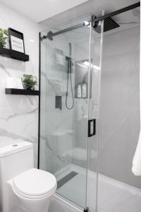 y baño con ducha y aseo. en French Charm in Brampton 2 Bdrm Apt, en Brampton