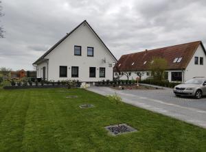 a white house with a car parked in front of it at Rügen Fewo 301 in Haidhof
