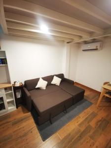 Proud Room & wifi في شمال باتايا: غرفة معيشة مع أريكة بنية في غرفة
