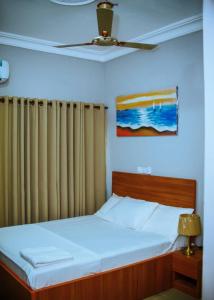 1 dormitorio con 1 cama y ventilador de techo en Estben guesthouse, en Kwabenyan