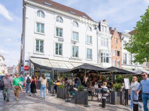 a group of people walking around a market in front of a building at Lace Hotel in Bruges