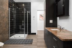 a bathroom with a shower with black tiles at Boutique Lofts Notre Dame in Montr&eacute;al
