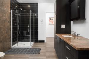 uma casa de banho com um chuveiro com azulejos pretos em Boutique Lofts Notre Dame em Montreal