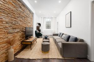 uma sala de estar com um sofá e uma parede de tijolos em Boutique Lofts Notre Dame em Montreal