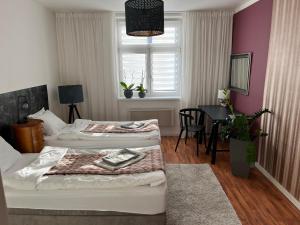 a bedroom with two beds and a dining room with a table at Pension Skylark in Pardubice