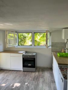uma cozinha com armários brancos e um fogão em Family & Friends apartments - Mrežnica em Duga Resa