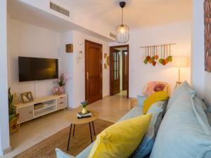 ein Wohnzimmer mit einem blauen Sofa und einem Fernseher in der Unterkunft El descanso de Wallada - Tranquilidad y Confort in Córdoba