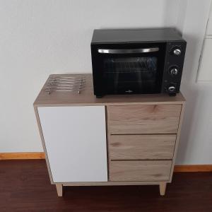 a microwave oven sitting on top of a dresser at T2 confortable - Piscine chauffée - Super Besse in Besse-et-Saint-Anastaise