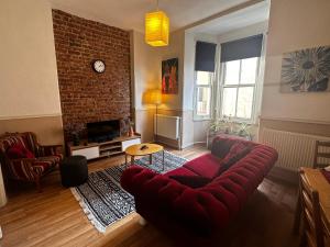 a living room with a red couch and a brick wall at Apartment in Great Location in Kadıkoy Seaside w. Amazing Shared Terrace in Istanbul