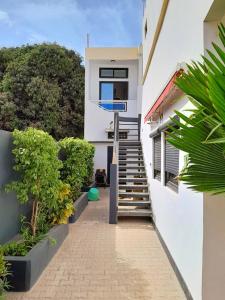 a stairway leading to a white building with trees at Studio Cozy in Sali Tapé