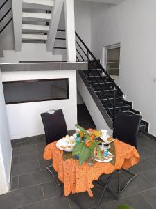 a dining room with a table and chairs and stairs at Studio Cozy in Sali Tapé