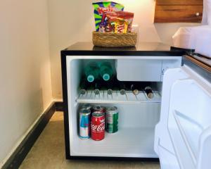 um frigorífico aberto com bebidas e uma cesta de snacks em Pousada Panorama Cipo em Santana do Riacho