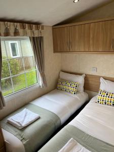 um pequeno quarto com duas camas numa caravana em Natland Caravan Park em Kendal