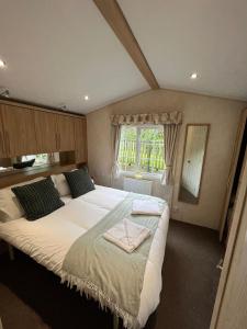 una camera con un grande letto e una finestra di Natland Caravan Park a Kendal