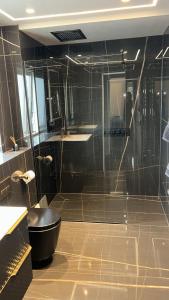 ein Bad mit einer Dusche und einer schwarzen Badewanne in der Unterkunft Riversdale House Next to Murrayfield Stadium in Edinburgh